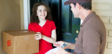 Delivering a Package Delivery man brings a package to a customer's door and waits for a signature.